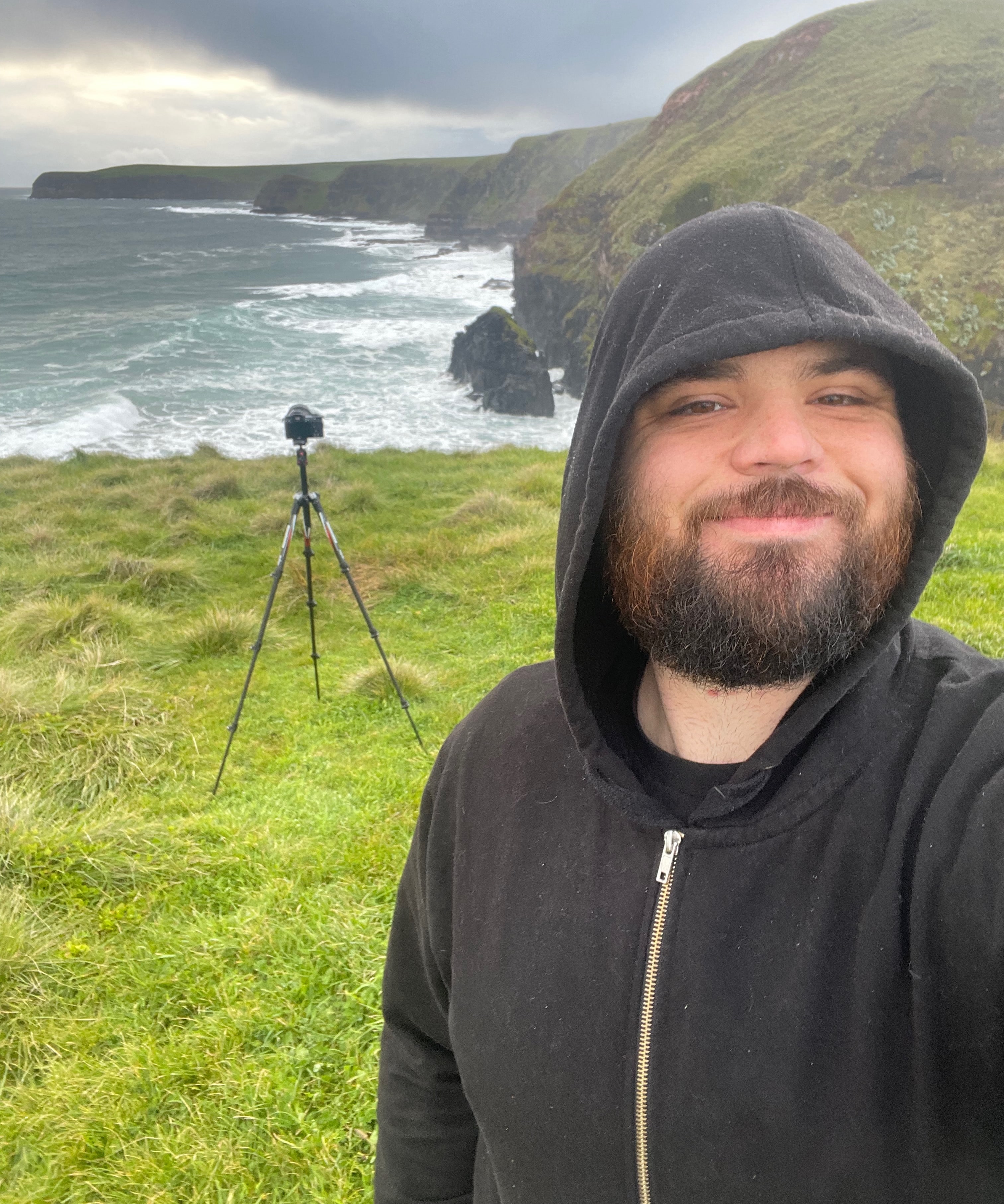 James standing on the cliffs with his camera behind him